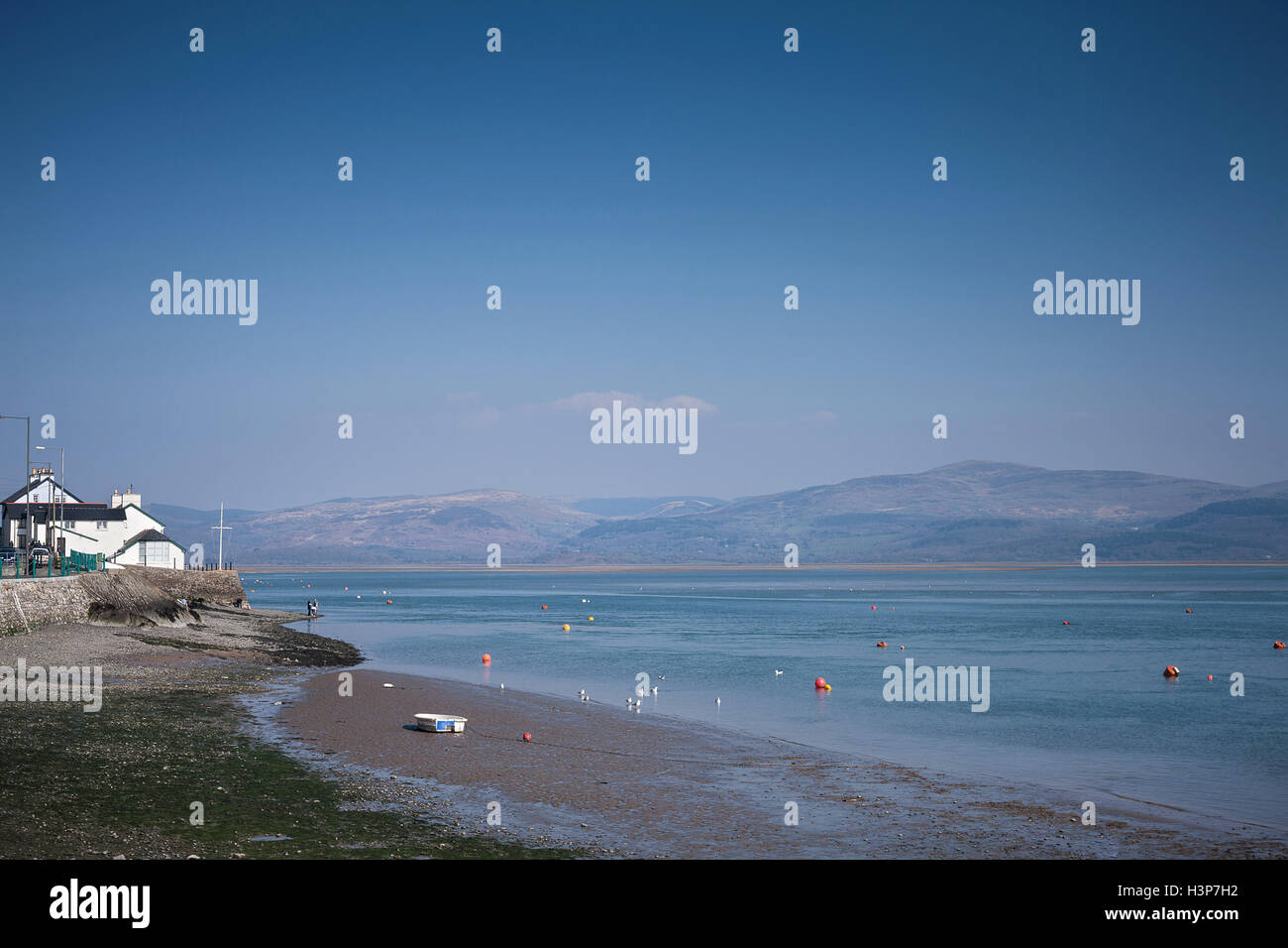 Strand und Mündung bei Aberdyfi / Aberdovey Wales mit Gebäuden und Boot Berge Snowdonia mit blauem Himmel und Meer Stockfoto