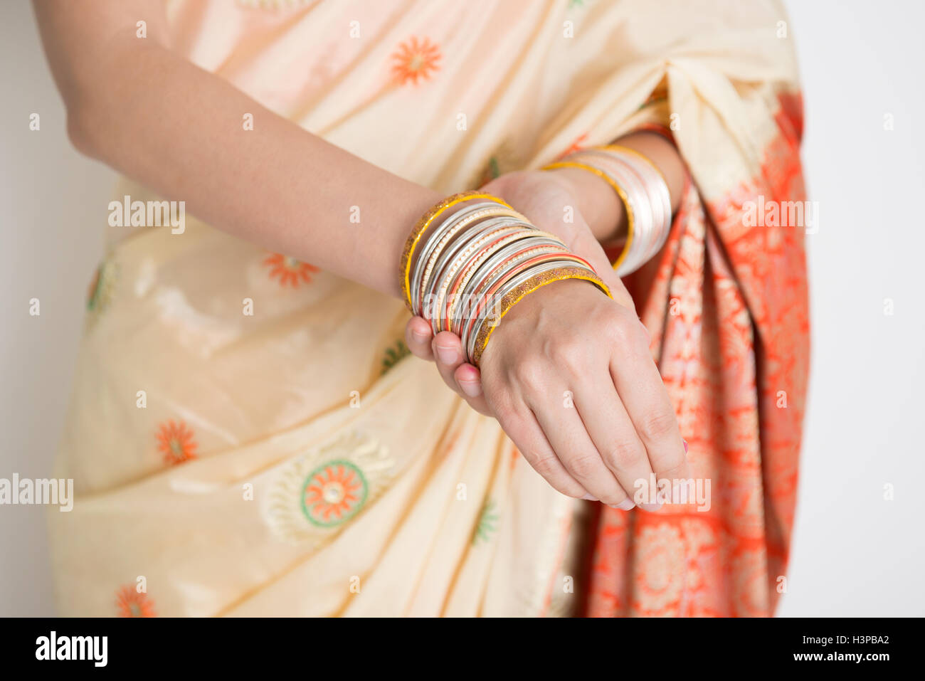 Helle Haut Inderin in traditionellen Sari Kleid tragen Armreifen, stehend auf einfarbigen Hintergrund. Stockfoto Helle Haut Inderin in traditionellen Sari Kleid tragen Armreifen, stehend auf einfarbigen Hintergrund. Stockfoto
