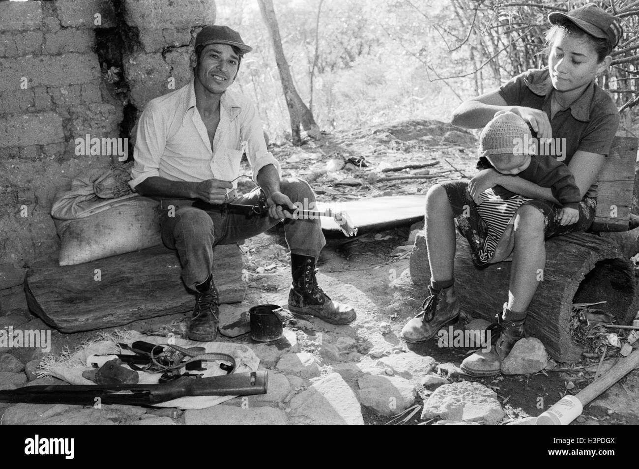 CHALATENANGO, EL SALVADOR, FEB 1984: - innerhalb der FPL Guerilla Zonen der Steuerung Evaristo, ein Mitglied der Miliz PPL Reinigung seine Waffe. Stockfoto