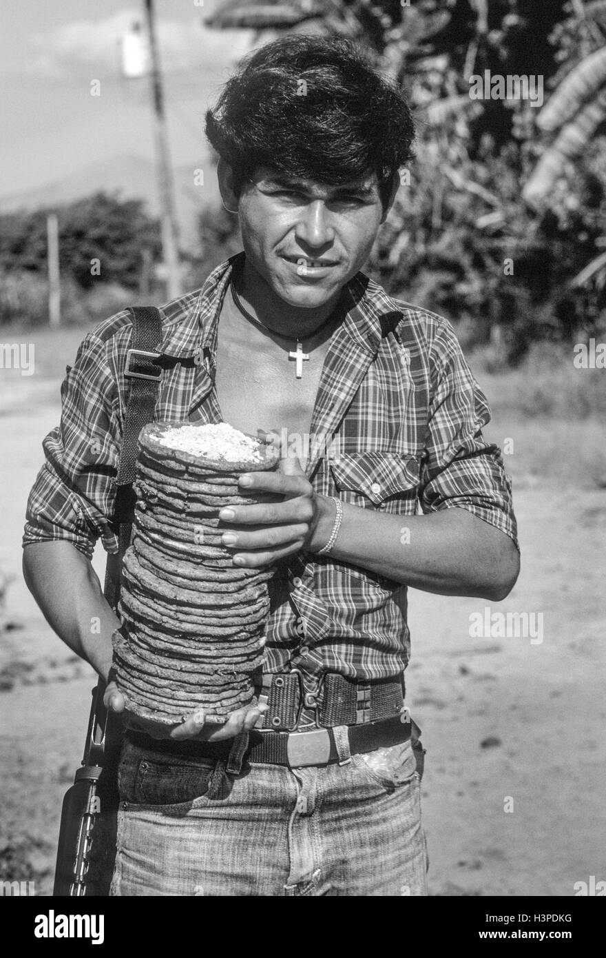 TENANCINGO, EL SALVADOR, März 1984: - im Rahmen der FPL-Guerilla Zonen des Steuerelements. Ein FPL-Kämpfer mit einem Stack von Tortillas und Salz. Stockfoto