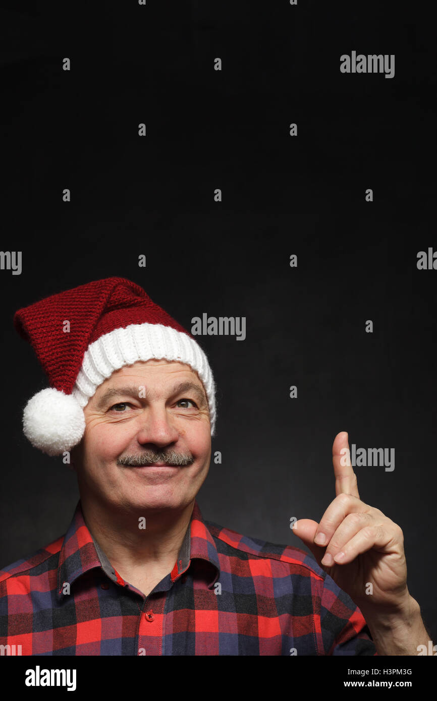 Mann mit einem Schnurrbart in GAP von Weihnachten zeigt Zeigefinger nach oben. Stockfoto