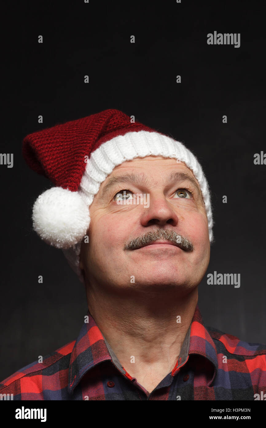 Mann in Weihnachtsmütze nachschlagen Stockfoto