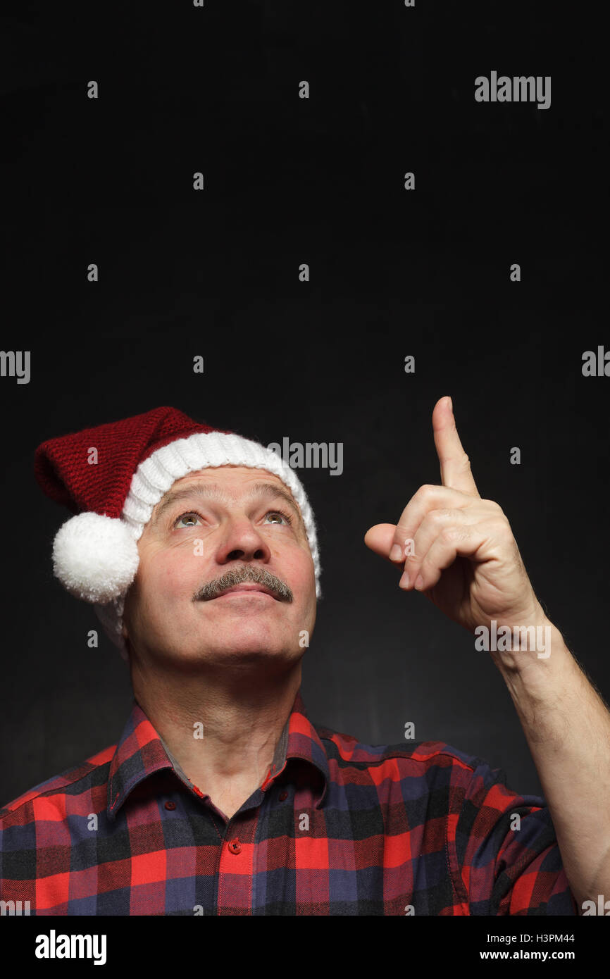 Mann mit einem Schnurrbart in GAP von Weihnachten zeigt Zeigefinger nach oben. Stockfoto