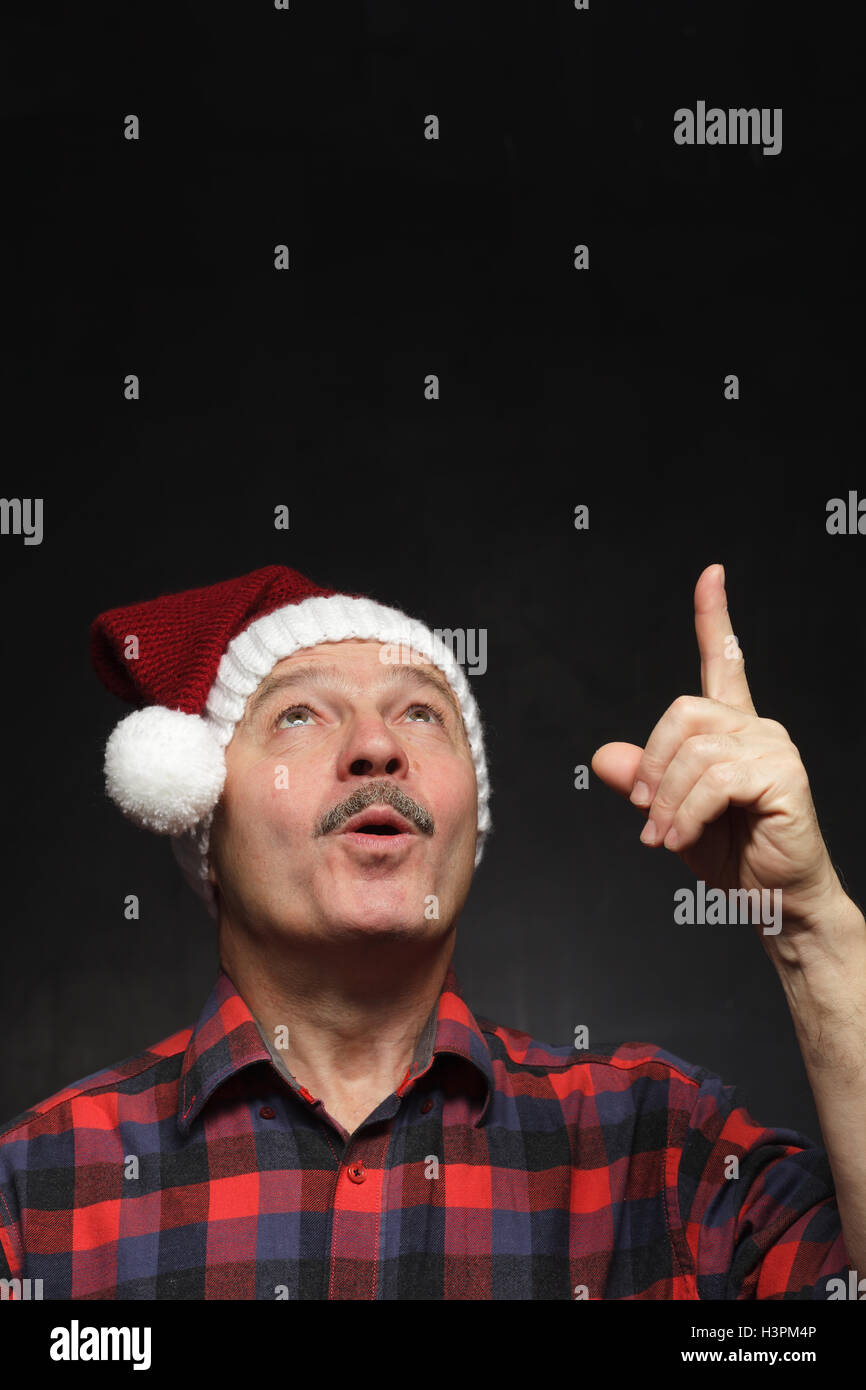Mann mit einem Schnurrbart in GAP von Weihnachten zeigt Zeigefinger nach oben. Stockfoto