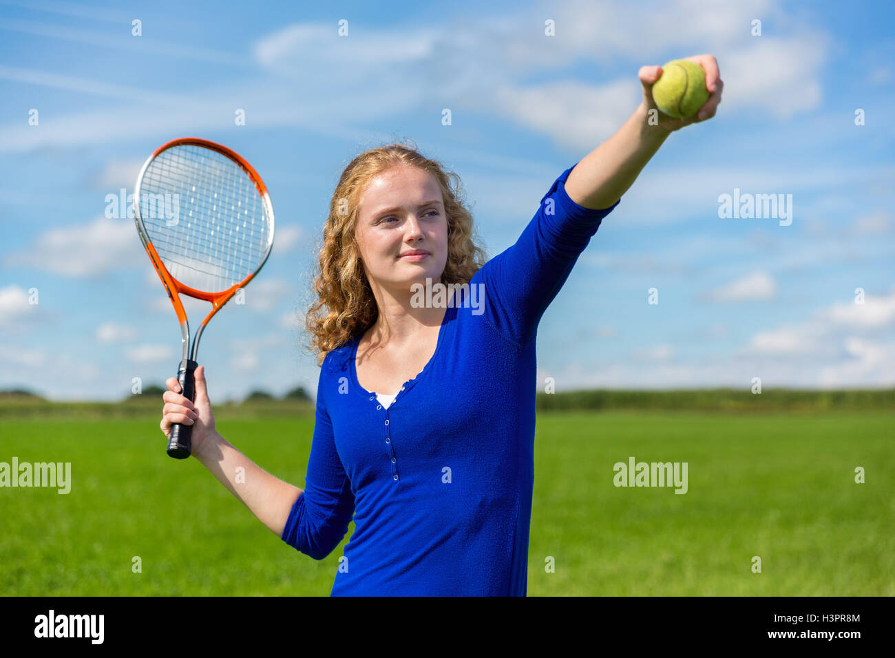 Kaukasische Mädchen halten Tennisschläger und Tennisball außerhalb Stockfoto