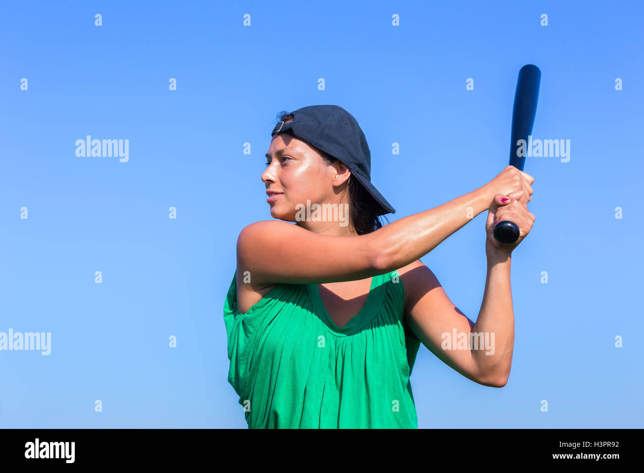 Junge Frau mit Baseballschläger und GAP im blauen Himmel Stockfoto