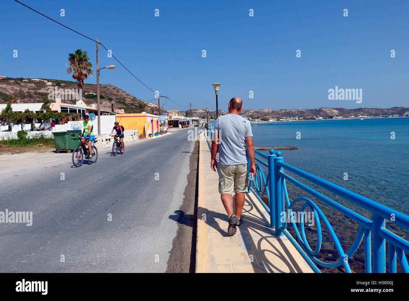 Mann zu Fuß entlang der Strandpromenade in der griechischen Dorf Kefalos auf der Dodekanes Insel Kos Stockfoto