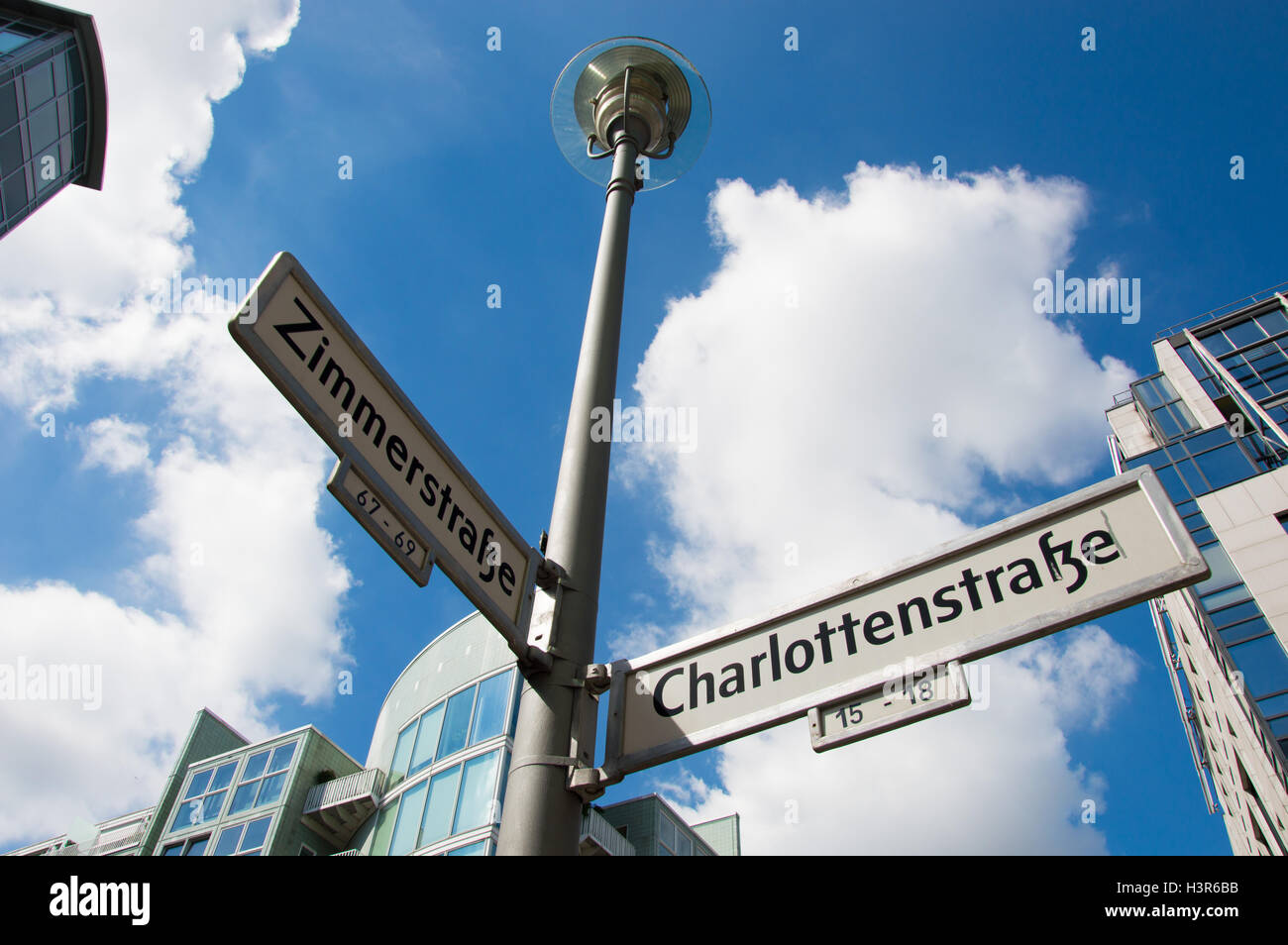 Straßenschild auf Zimmerstraße und Charlottenstrasse mit Gebäuden und Himmel Wolken im Hintergrund Stockfoto