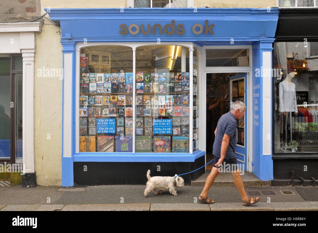 Ein Mann in seinen späten 50er Jahre Vorbeigehen einen second-hand Plattenladen in Falmouth, Cornwall. Stockfoto