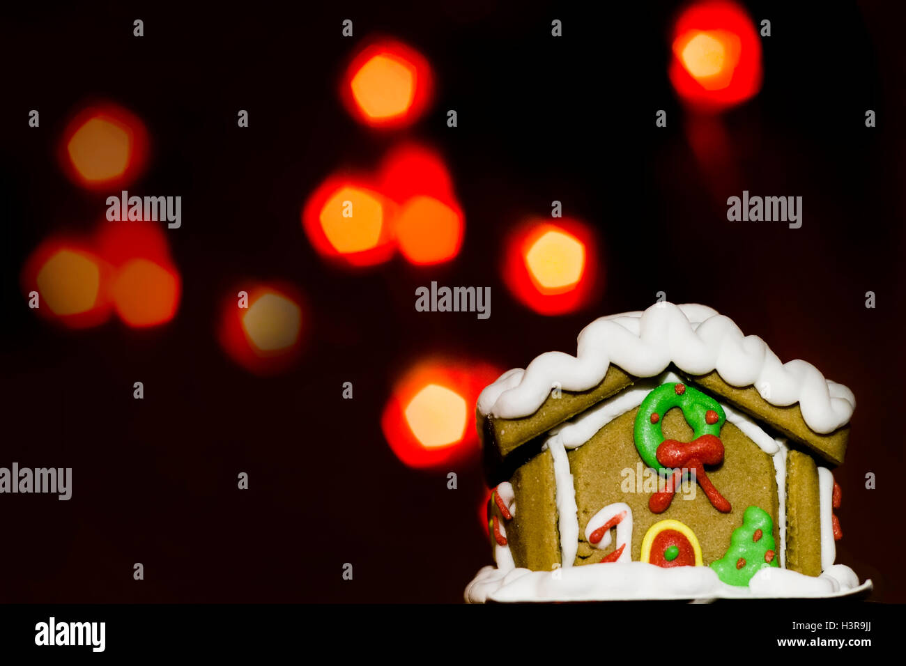 Lebkuchenhaus und über defokussierten Lichter. Weihnachten Hintergrund. Stockfoto