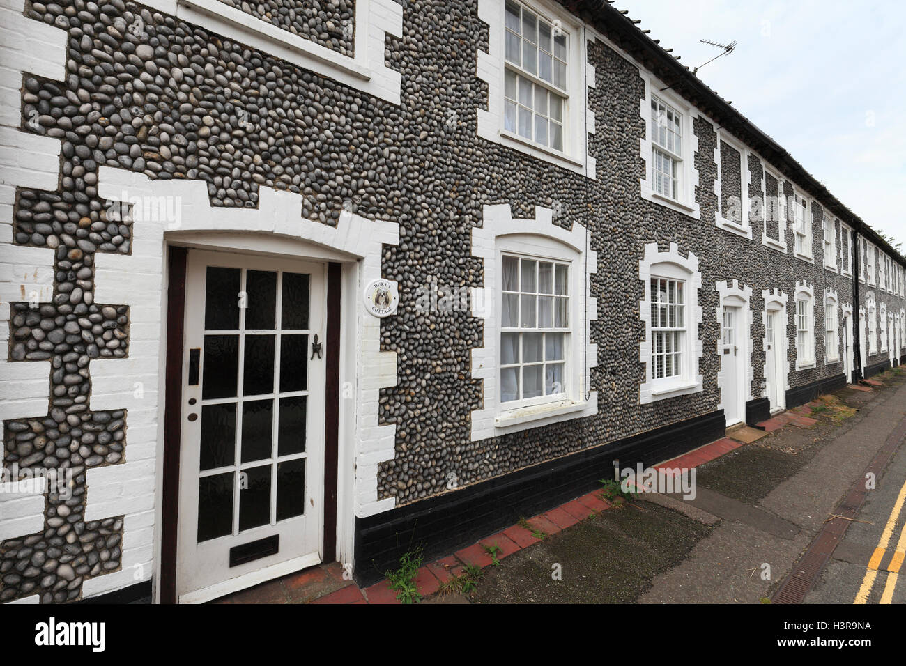 Eine Reihe von Feuerstein, terrassenförmig angelegten Bungalows in Holt, Norfolk, England. Stockfoto