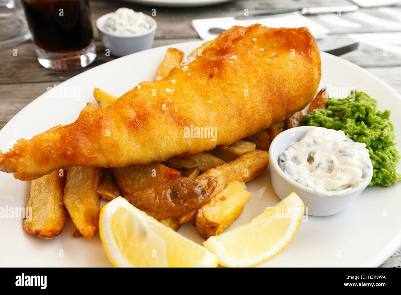 Restaurant Fish And Chips mit Remoulade, Zitrone und Erbsenpüree. Stockfoto