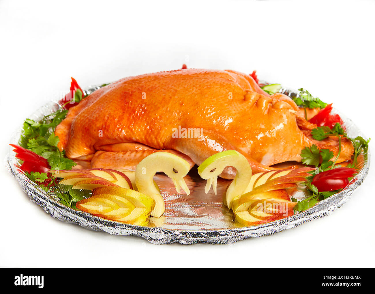 Geröstete Ente mit Äpfeln und Salat. Schnitzen - aus einem Apfel sieht aus wie zwei Schwäne Stockfoto