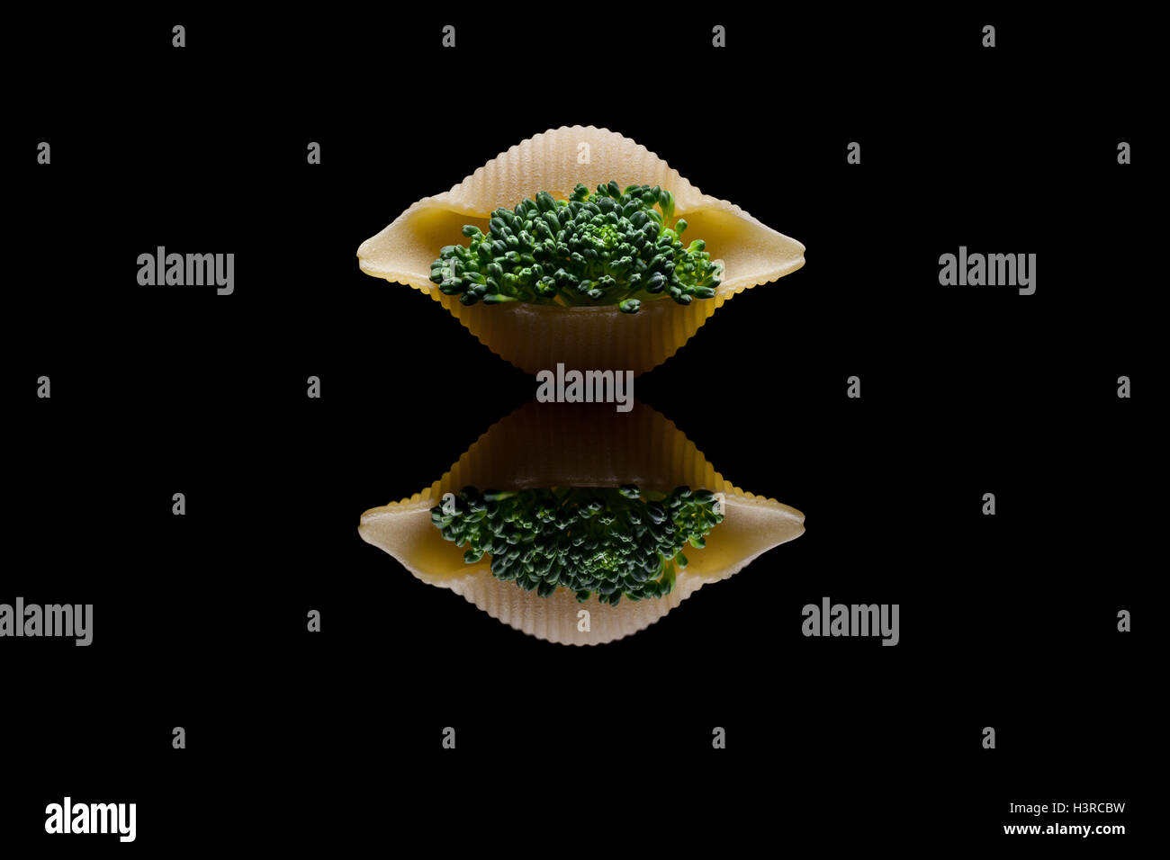 Grünen Brokkoli in Schale Nudeln auf einem schwarzen Reflexion Hintergrund eingebettet Stockfoto