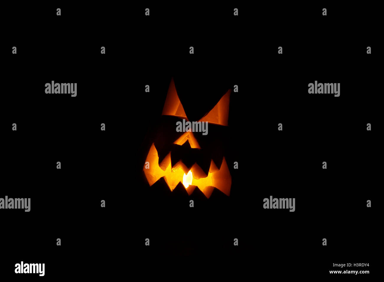 Scary Halloween Gesicht geschnitzt in einen Kürbis mit einem Licht im Inneren Stockfoto
