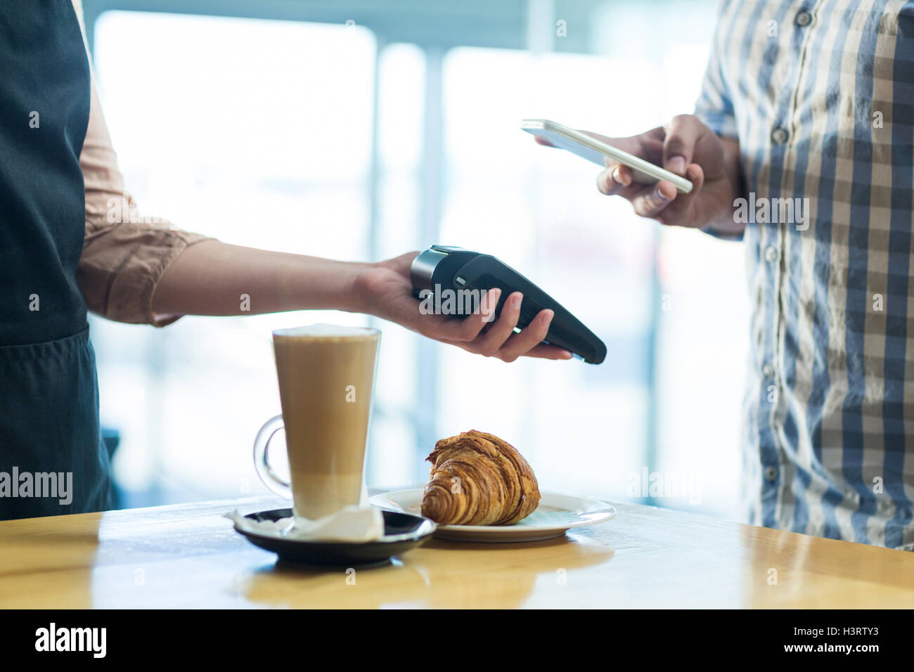 Mann, die Zahlung der Rechnung durch Smartphone mit NFC-Technologie Stockfoto