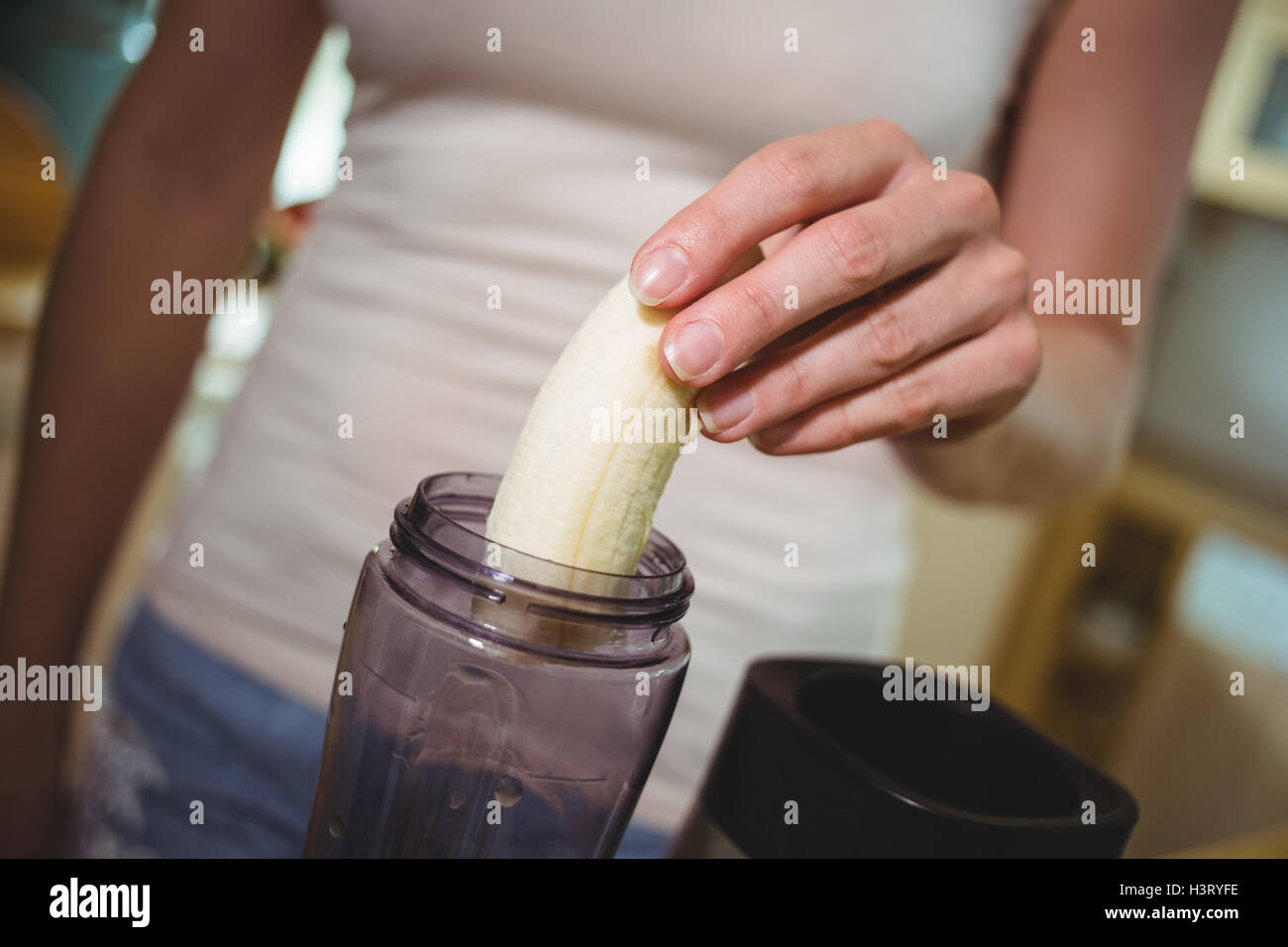 Frau Vorbereitung Banane smoothie Stockfoto