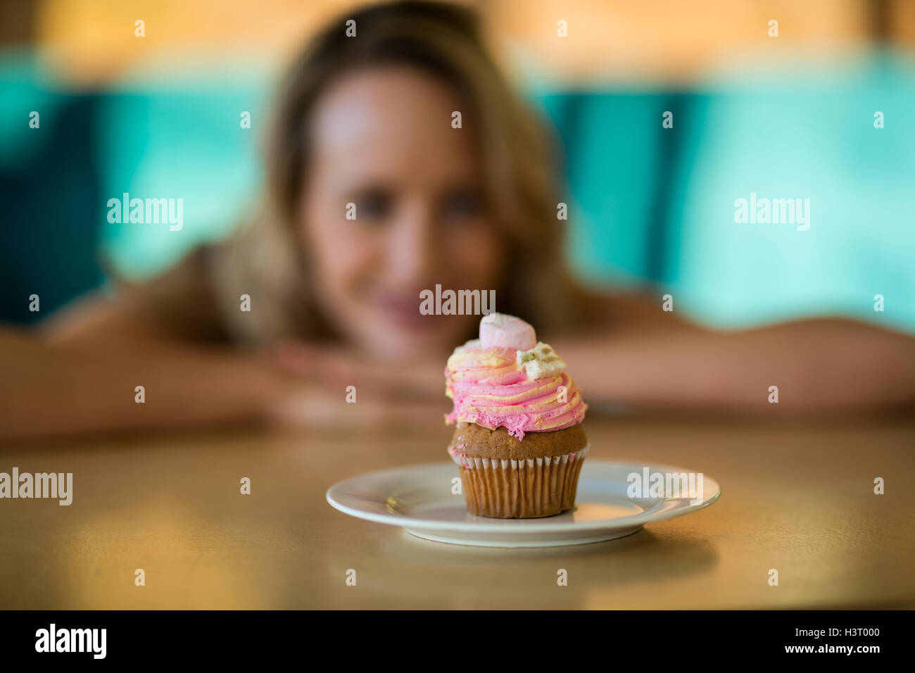 Frau betrachten Cupcake auf Platte Stockfoto