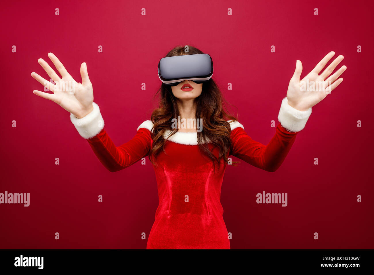 Portrait von junge Brünette Frau in rotem Samt-Kleid mit virtual-Reality-Kopfhörer Stockfoto