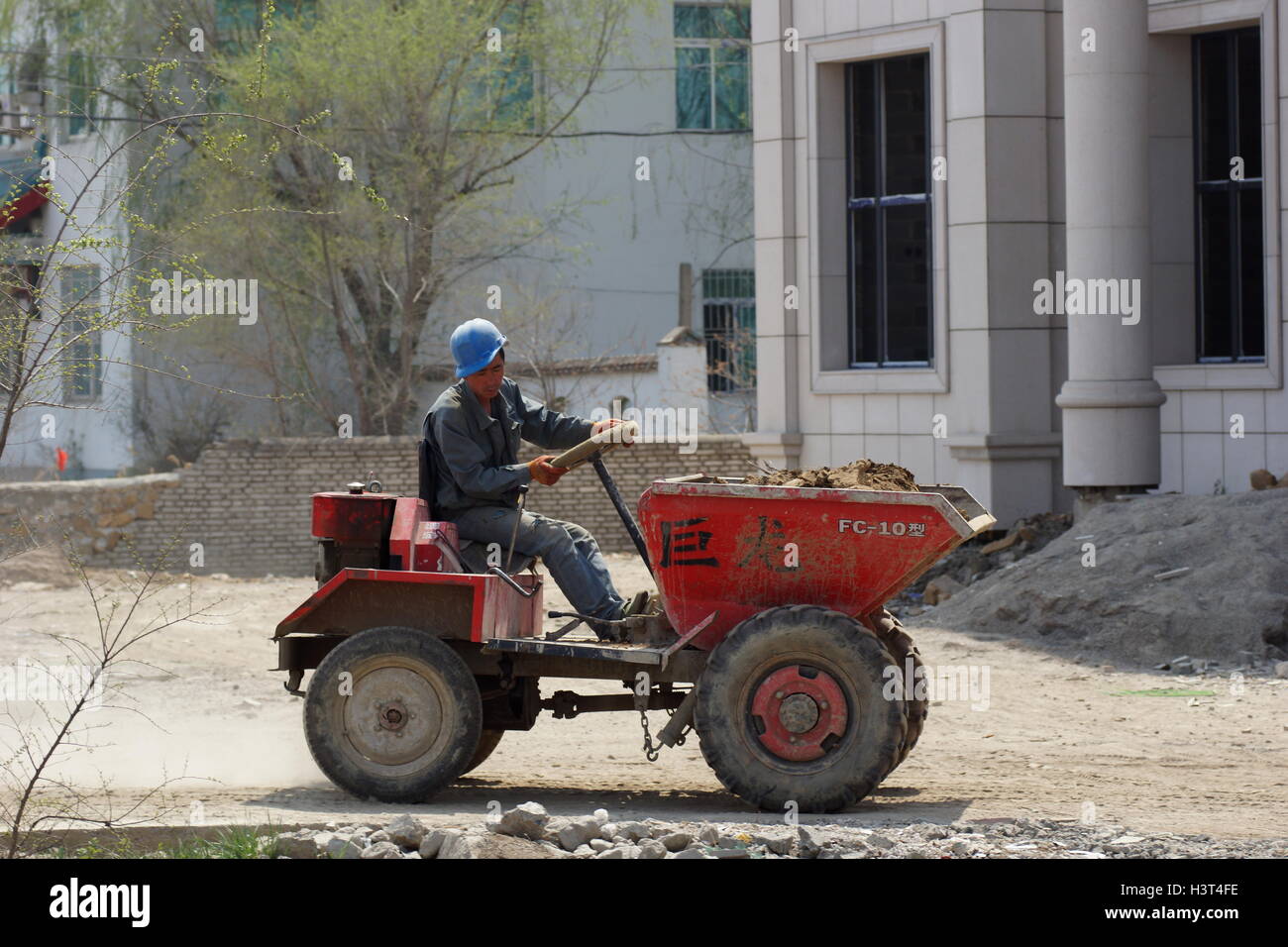 Chinesische Arbeiter in einem Mini-Traktor Stockfoto