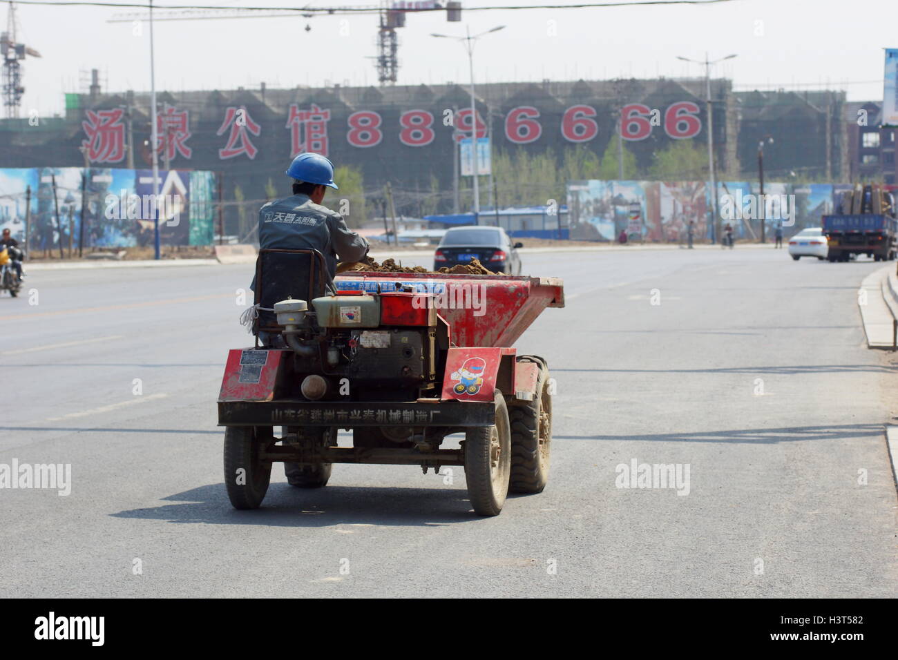 Chinesische Arbeiter in einem Mini-Traktor Stockfoto