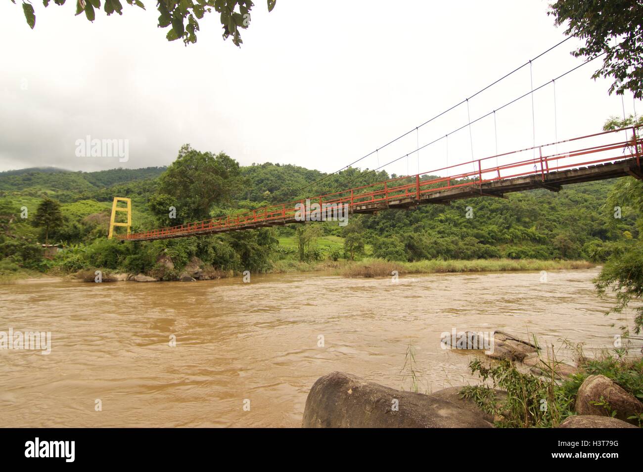 Hölzerne Hängebrücke über den Fluss Kok in Chiangrai den Norden von Thailand. Stockfoto
