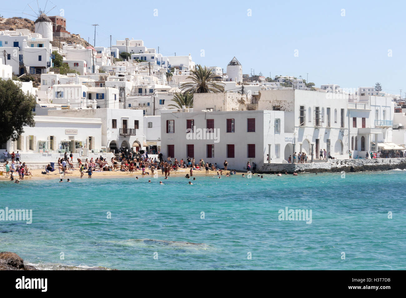 Menschen am Strand mit der Stadt Chora hinter, Mykonos, Griechenland Stockfoto