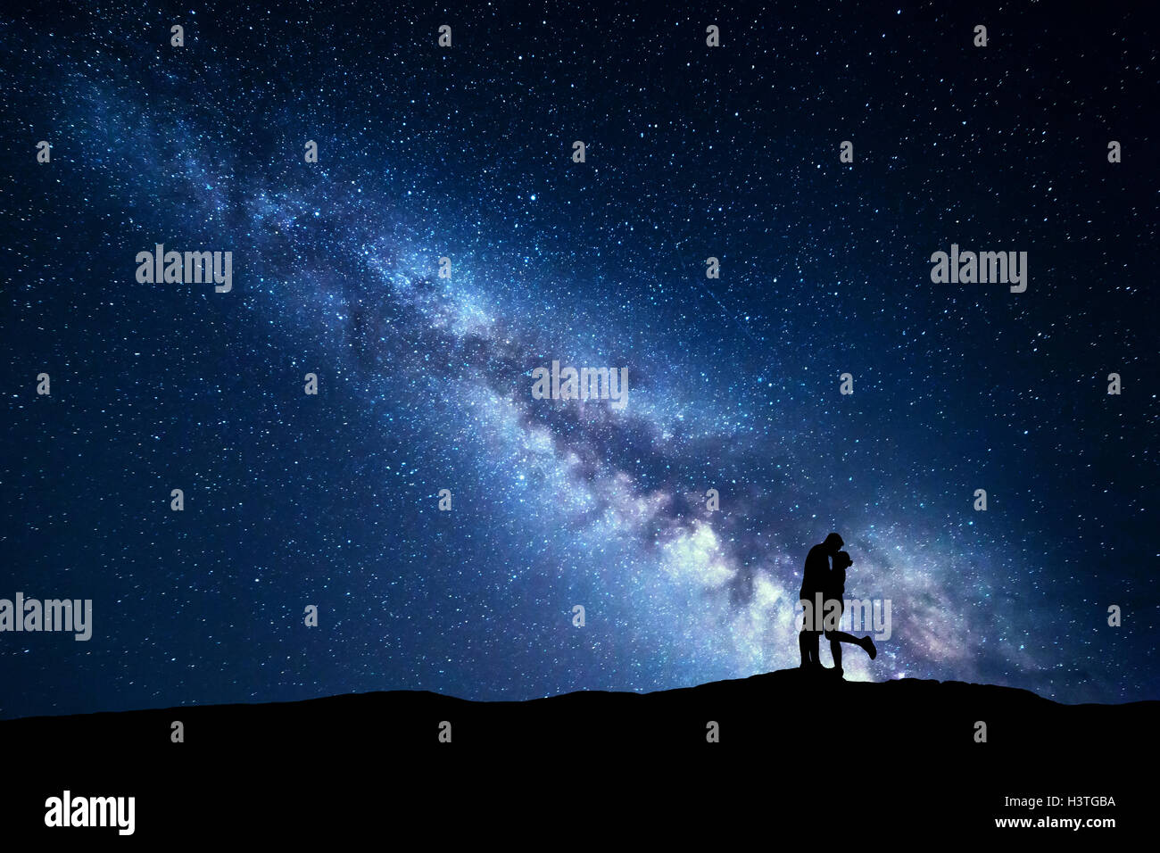 Milky Way. Nacht-Landschaft mit Silhouetten von umarmen und küssen, Mann und Frau auf dem Berg. Himmel mit Sternen. Silhouette der Stockfoto