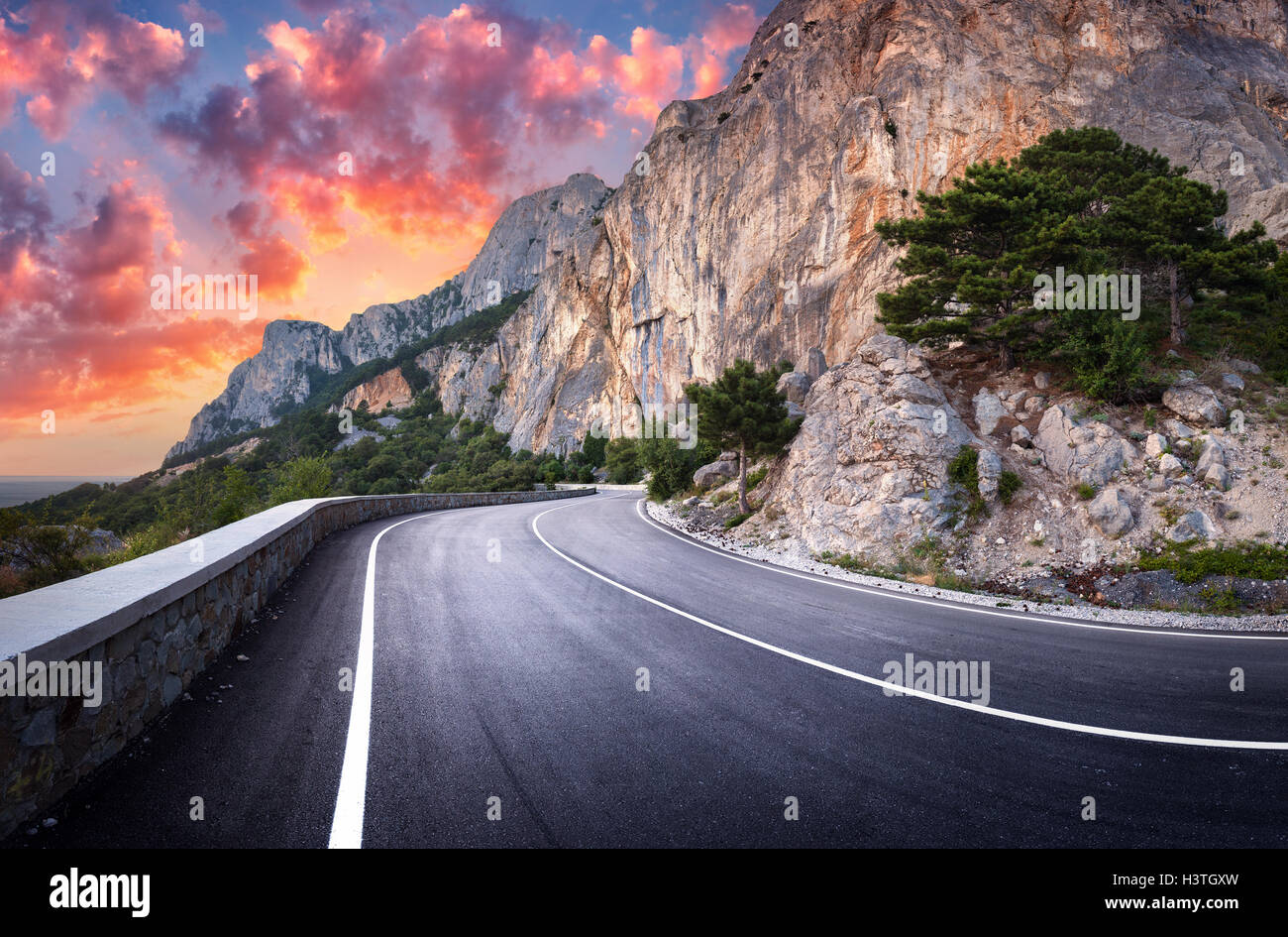 Asphaltierte Straße. Bunte Landschaft mit schönen kurvenreiche Bergstrasse mit perfekter Asphalt mit hohen Felsen, erstaunlich Himmel bei Sonne Stockfoto