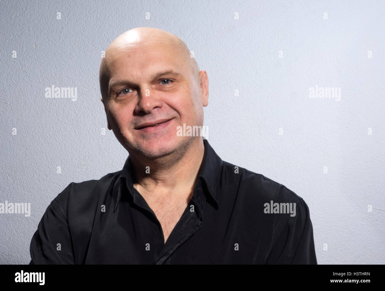Emotionale kaukasischen kahl reifer Mann im schwarzen Hemd. Lächeln auf den Lippen Stockfoto