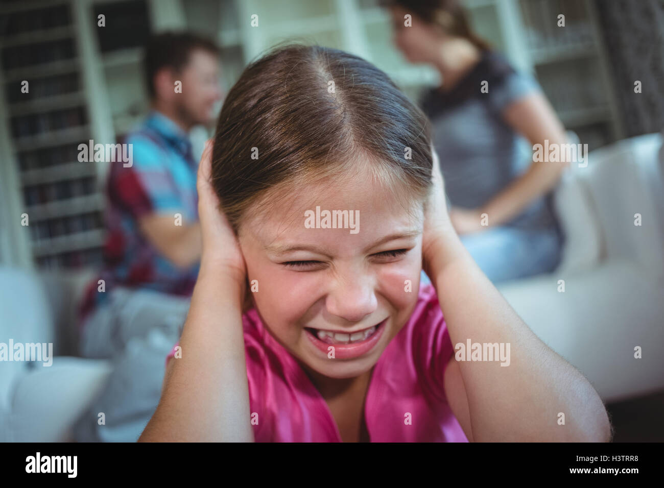 Trauriges Mädchen hören zu ihren Eltern streiten Stockfoto