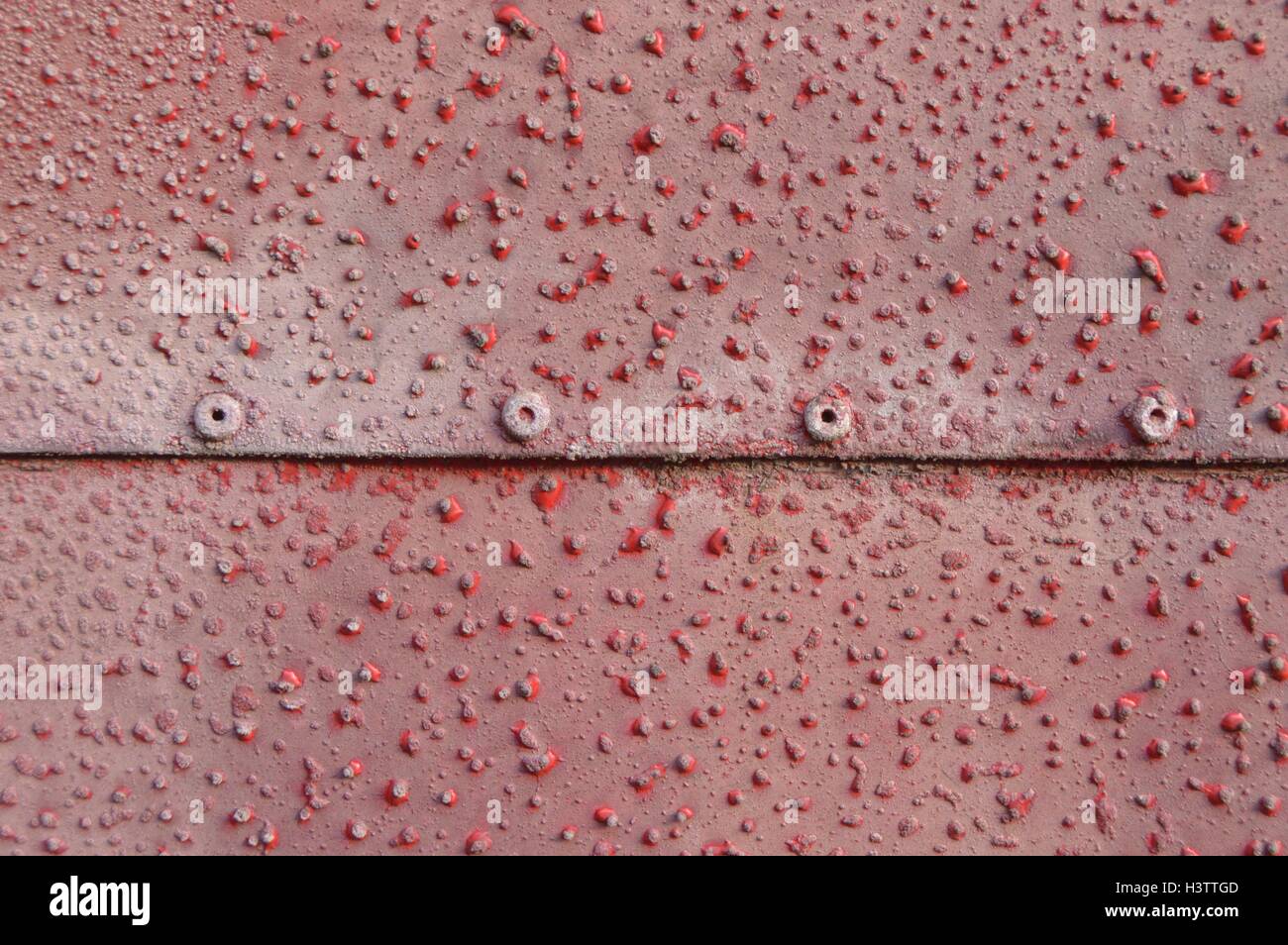 Blech mit roten Punkten. Foto von einem Blatt aus Metall mit einem roten Hintergrund und Textur rote Punkte hat. Stockfoto