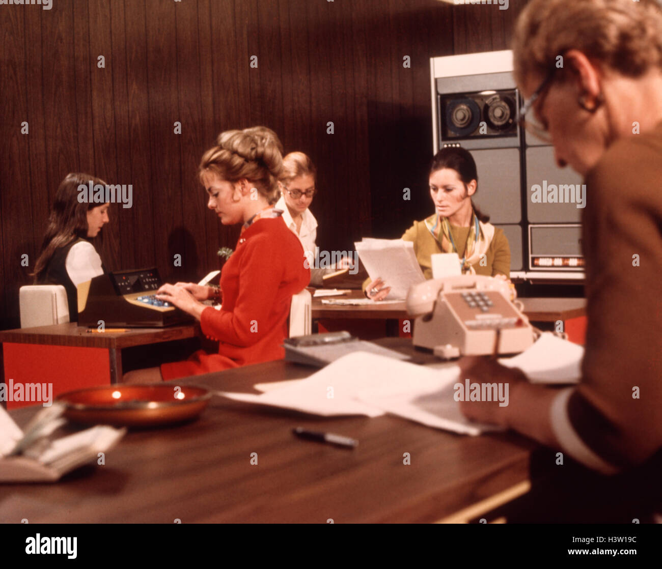 1970ER JAHREN ARBEITEN 5 FRAUEN BÜRO ARBEITER SCHREIBTISCHE COMPUTER MAINFRAME TELEFON PAPIERE SEKRETÄRIN SEKRETÄRINNEN Stockfoto