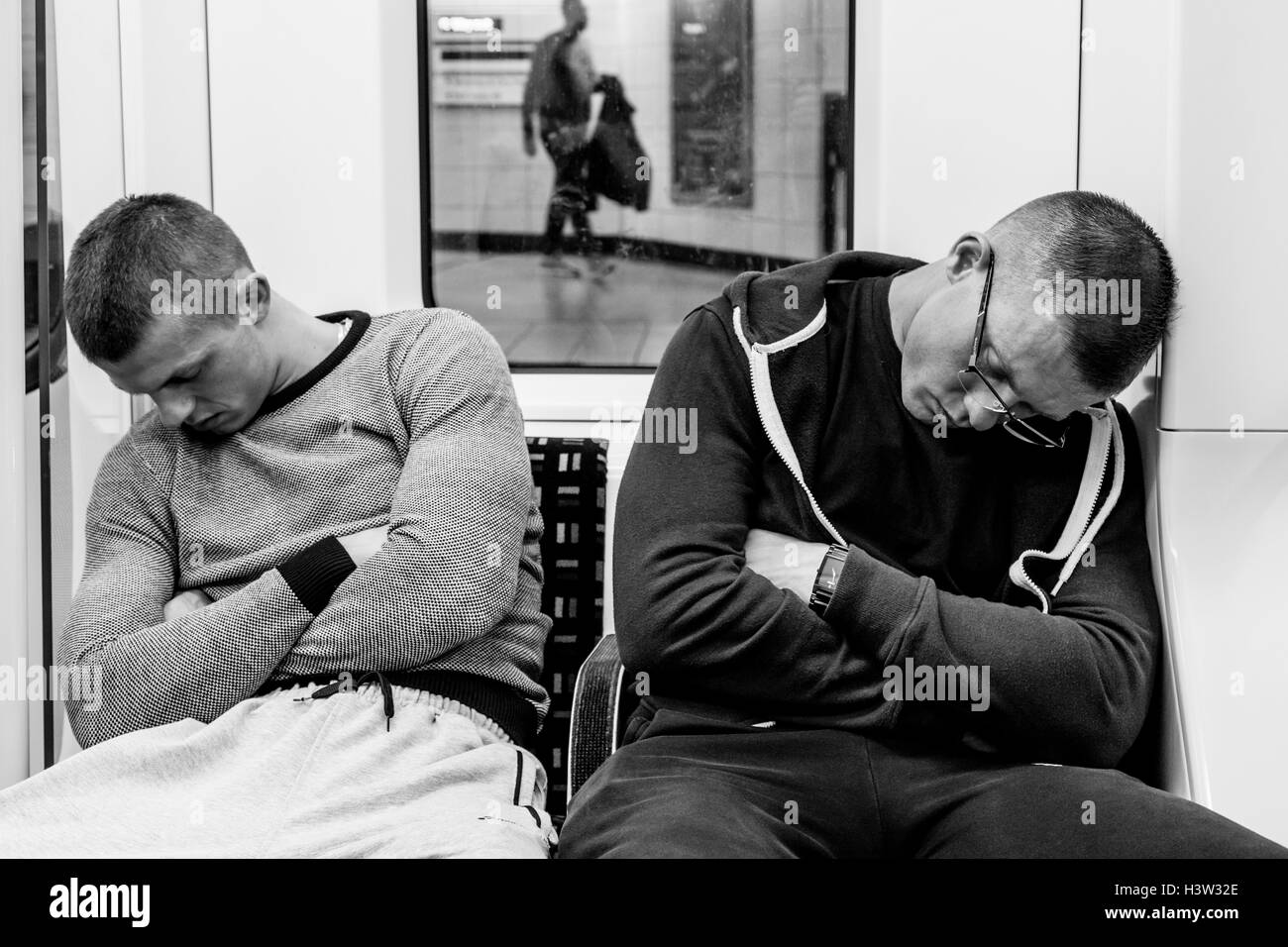 Zwei Männer schlafen auf einer Londoner U-Bahn Zug, London, UK Stockfoto