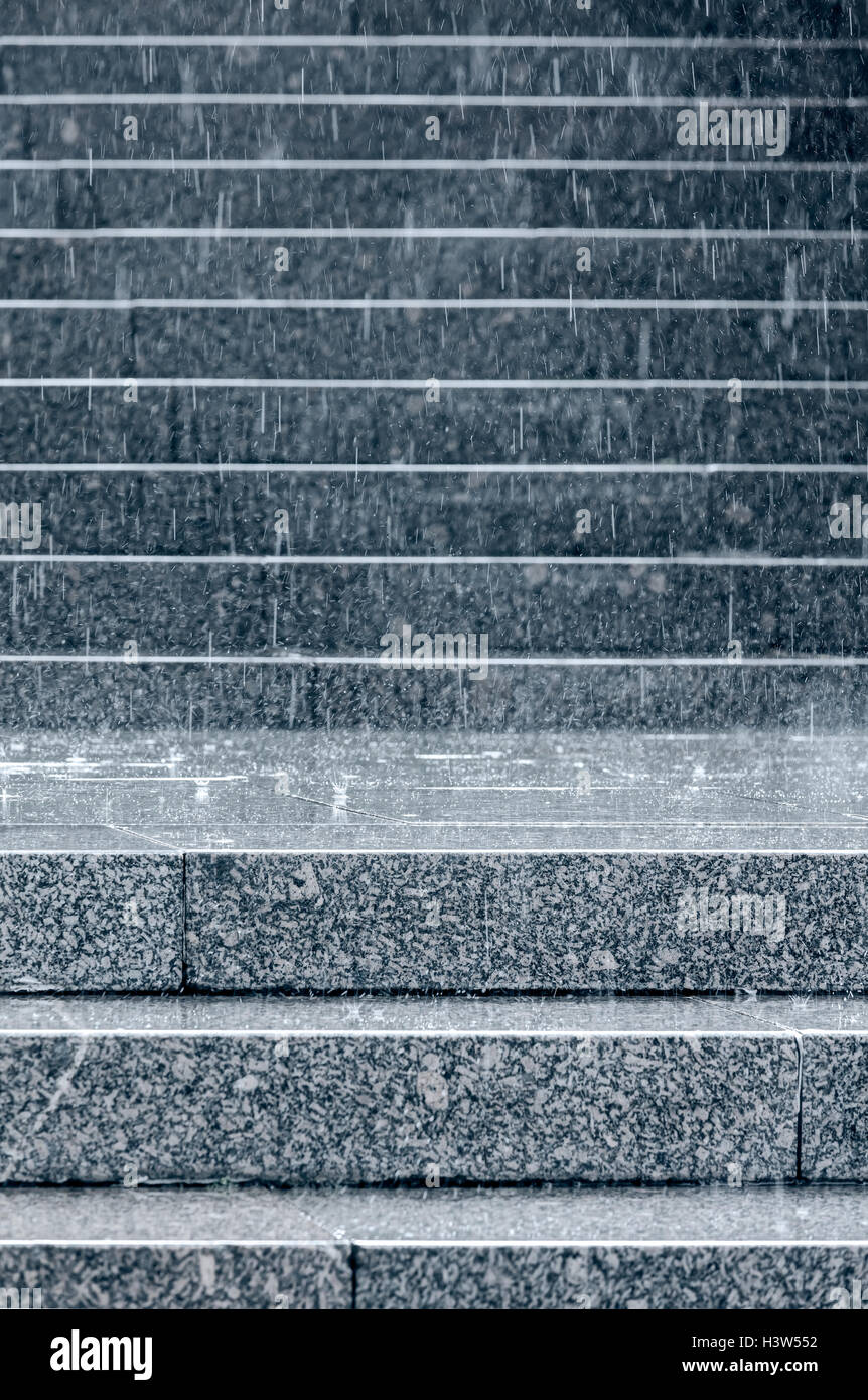 steinernen Stufen der Treppe mit Regentropfen Spritzwasser bei Regen Stockfoto