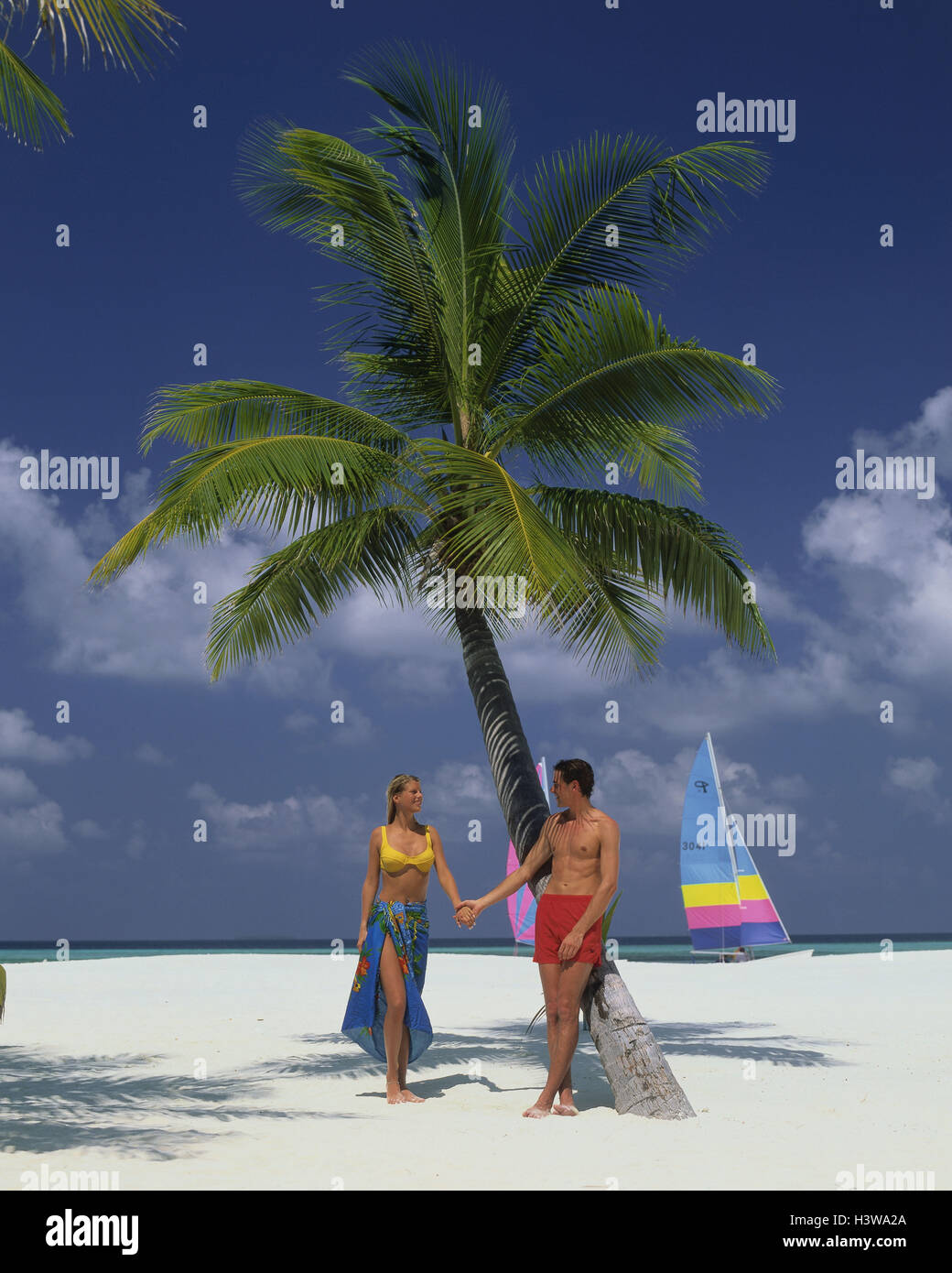 Paar, Strand, Palmen, Frau, Mann, Paero, Badehose, Katamaran, der Malediven, bewölkter Himmel, weißer Strand, draußen Stockfoto