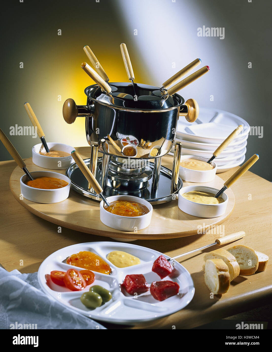 Fleischfondue, Teller, Saucen, Baguette, Stillleben, Produktfotografie, Fondue, Fleischgericht, Bourguignonne, Zweige, Löffel, Fonduetopf, Lebensmittel, Saucen, Brot Stockfotografie