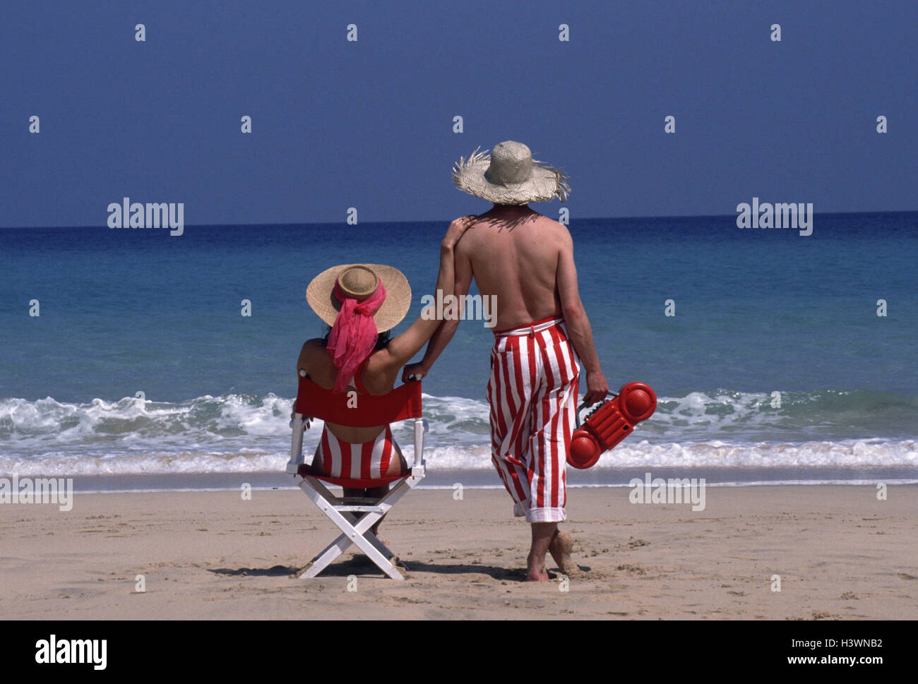 Sandstrand, paar, solar Hüte, Blick aufs Meer, Erholung, Rückansicht, Strand, Sand, Urlaub, Freizeit, Urlauber, Badeanzug, Hosen, Strohhüte, Kopfbedeckungen, Ansicht, Meer, Rest, nehmen Sie es einfach, zu genießen, Sonnenbad, Rest, Stille, angenehmes Gefühl, Sommerurlaub, Strandurlaub, Radio, Zweisamkeit, Zweisamkeit, Liebe Stockfoto