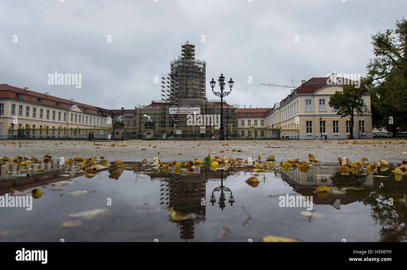 Berlin, Deutschland. 12. Oktober 2016. Teile des Schloss Charlottenburg spiegeln sich in einer Pfütze in Berlin, Deutschland, 12. Oktober 2016. Foto: PAUL ZINKEN/Dpa/Alamy Live News Stockfoto