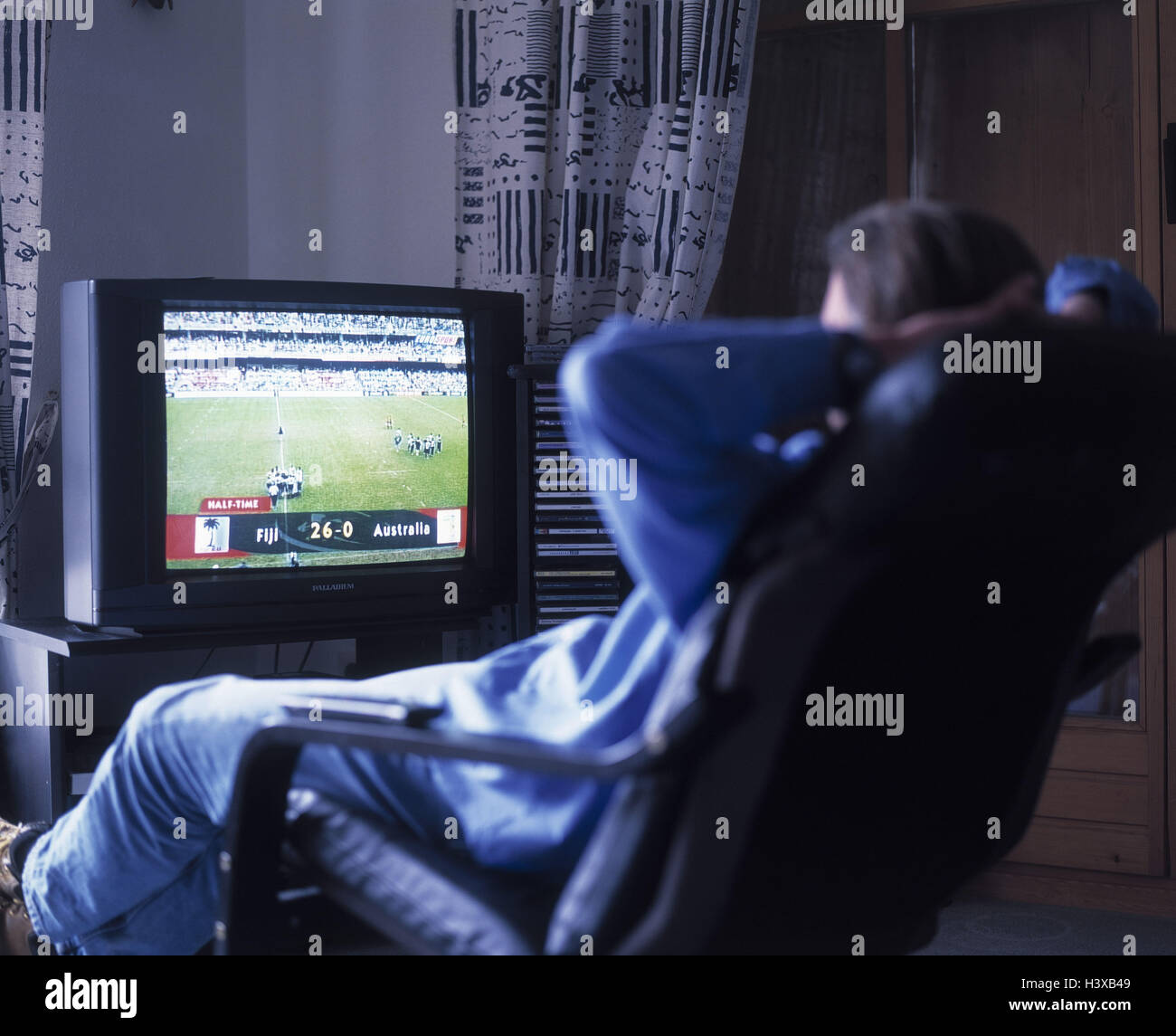 Mann, Fernsehen, Sport hochladen, zurück Blick Wohnzimmer, TV, TV-Sessel, Sport, Sportgetriebe, live-Übertragung, Erholung, Unterhaltung, Unterhaltungselektronik, schließen, Lebensstil Stockfoto