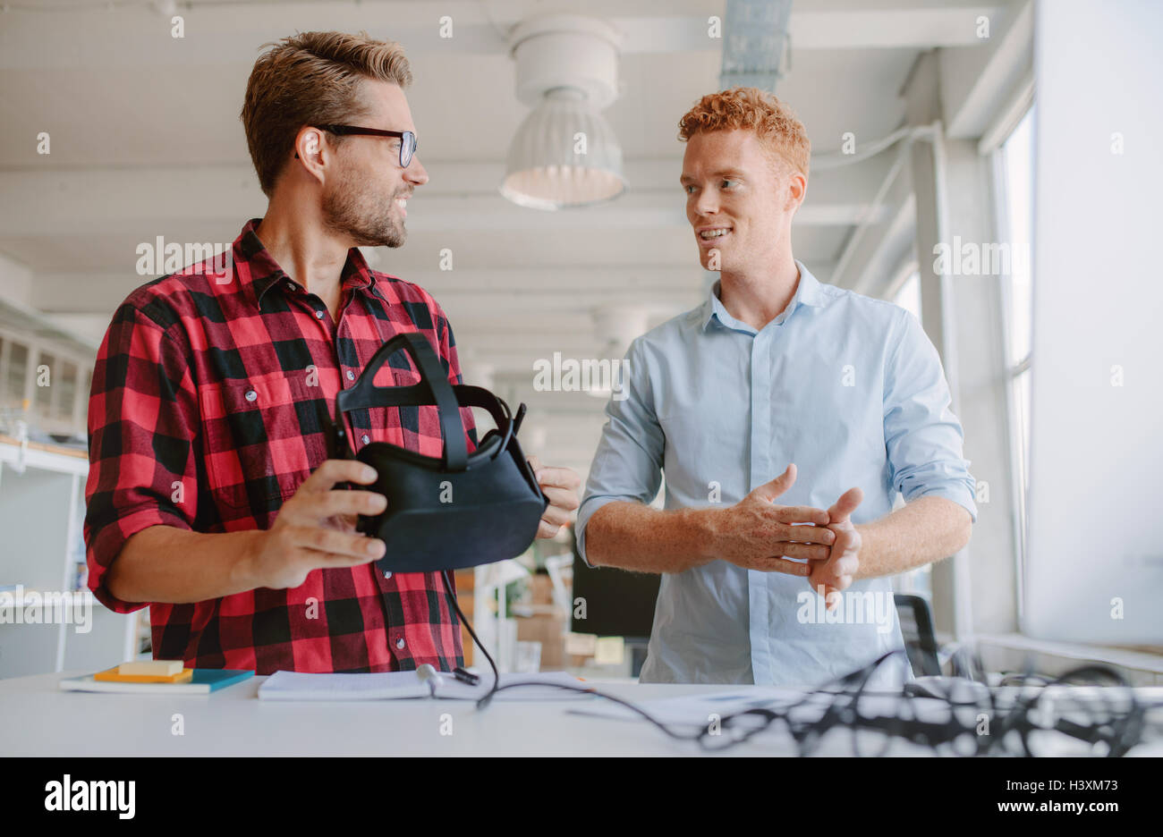 Aufnahme von zwei jungen Entwicklern diskutieren über neue virtual-Reality-Brille. Arbeiten an der Entwicklung neuer Kollegen Schutzbrillen VR Stockfoto