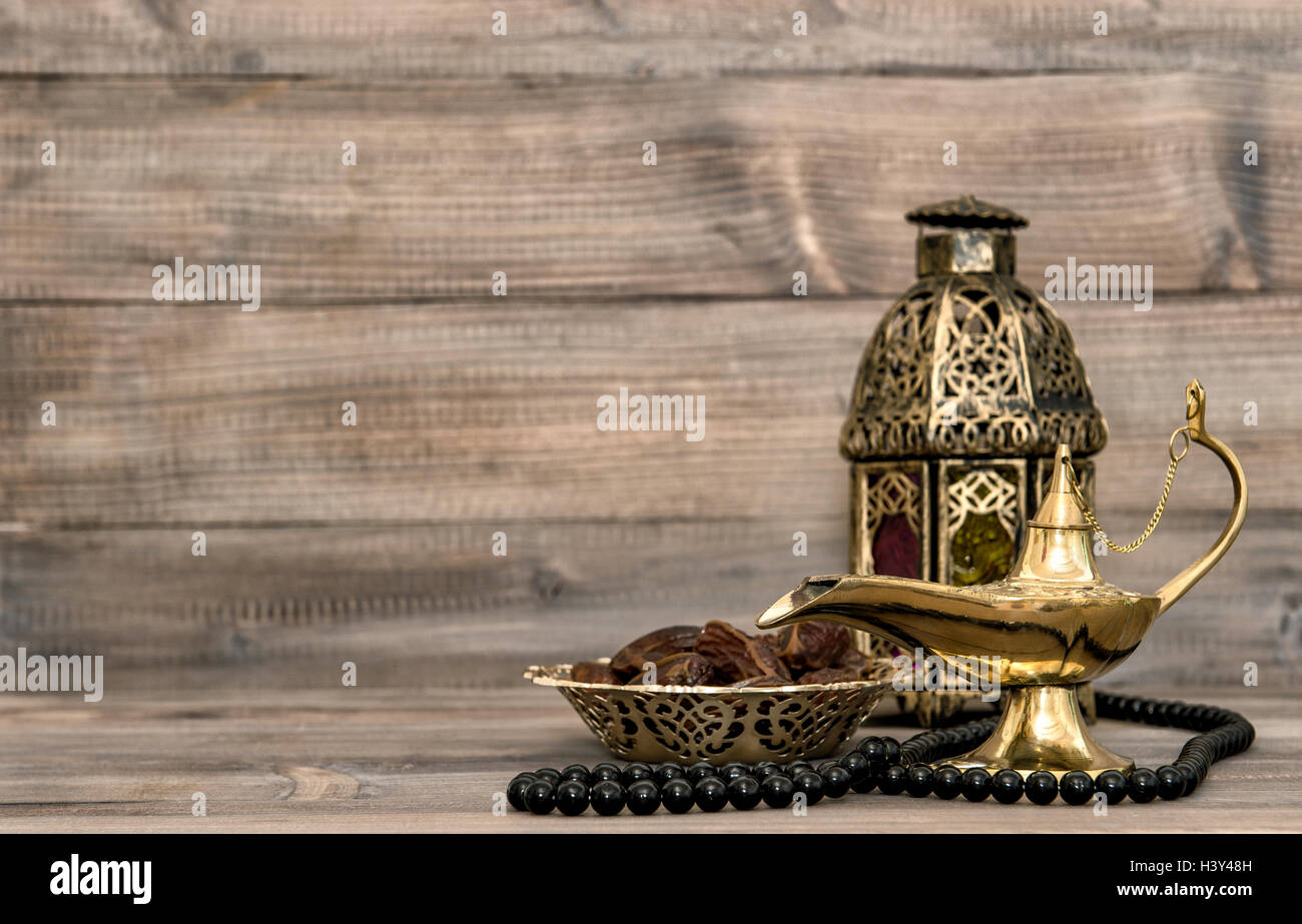 Orientalische Lampe und Termine auf hölzernen Hintergrund. Festlichen Stillleben mit Laterne und Rosenkranz Stockfoto