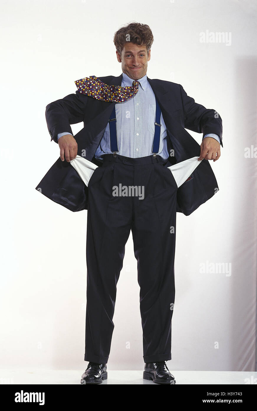 Mann im Anzug zeigt leere Hosentaschen, Studio mb 44 A3 Stockfoto