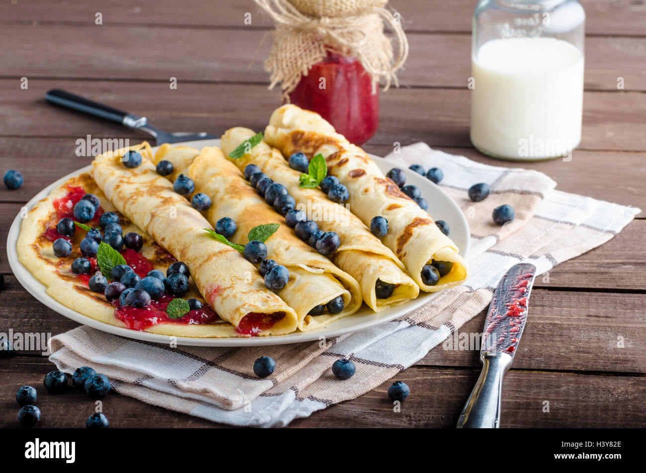Blaubeer-Muffins und Pfannkuchen, Milch und Marmelade im Hintergrund ...