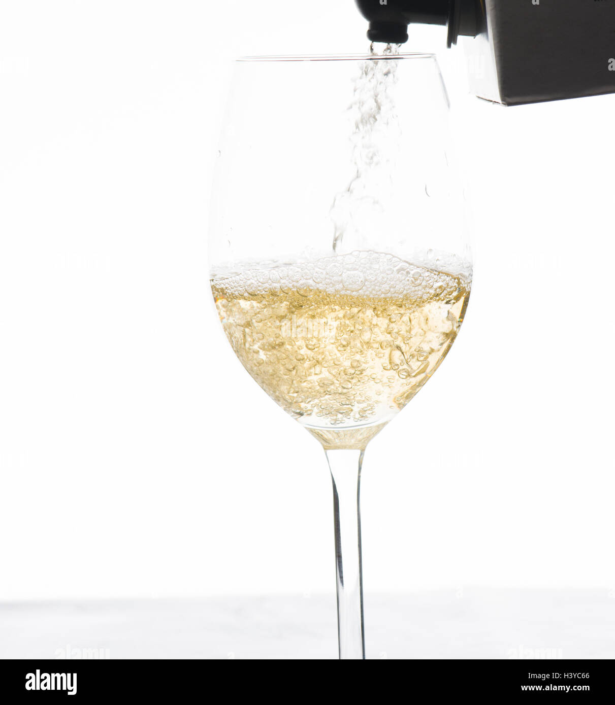 Weißwein aus Karton im Weinglas gießen. Stockfoto