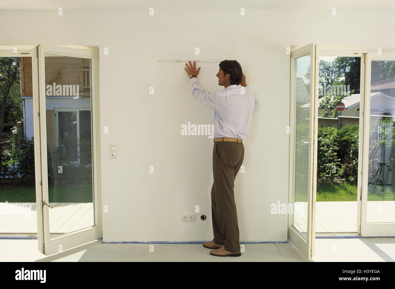 Flach, leer, Mann, skalieren, Wand, abmessen, innen, Zuhause, Haus, Neubau, Eigenheim, Werkzeuge, Länge Messgerät, Hof Stock, Maßnahme, Maßnahme, Messung, Inneineinrichtung, Office-Layout, Plan, Planung Stockfoto