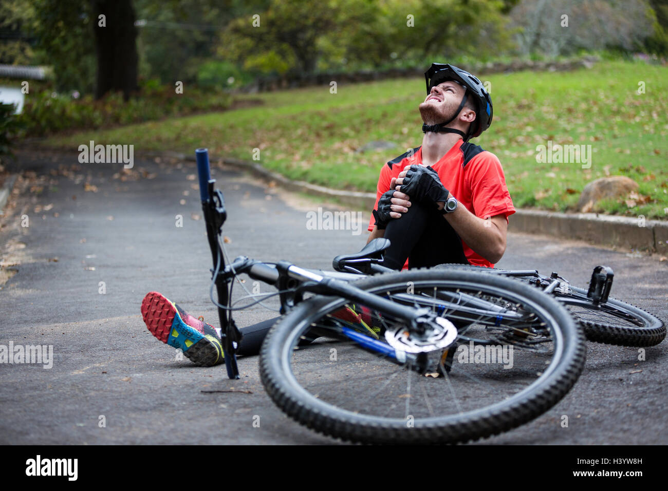 Männliche Radfahrer verletzt beim fallen vom Mountainbike Stockfoto