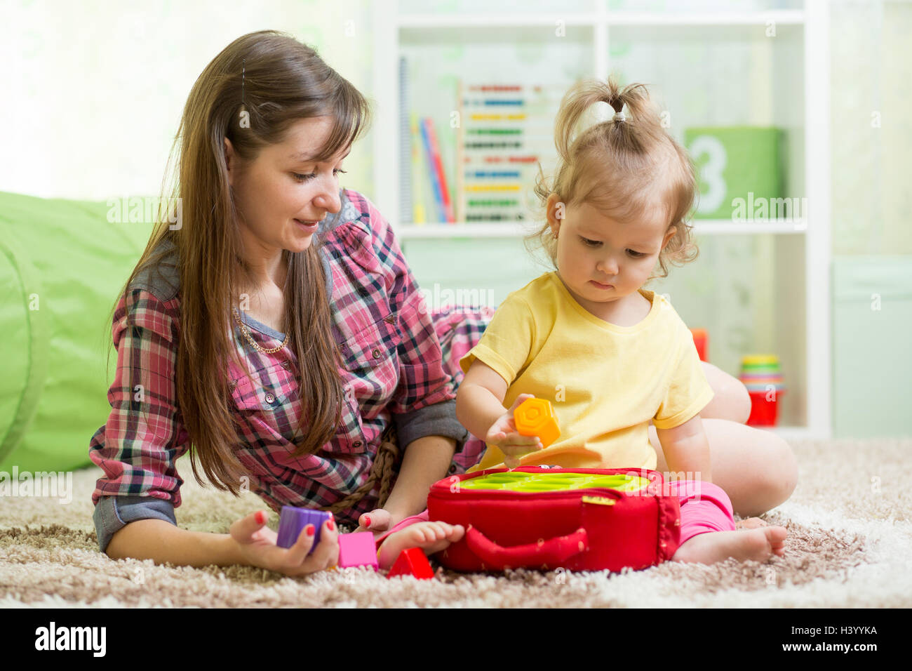 Baby mit Mutter spielen mit Bildungs-Spielzeug Stockfoto