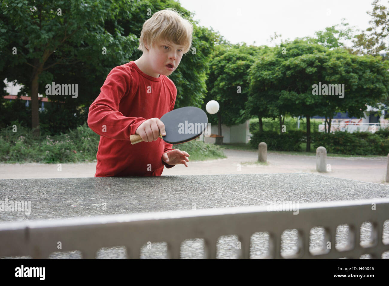 Behinderten jungen Tischtennis im park Stockfoto