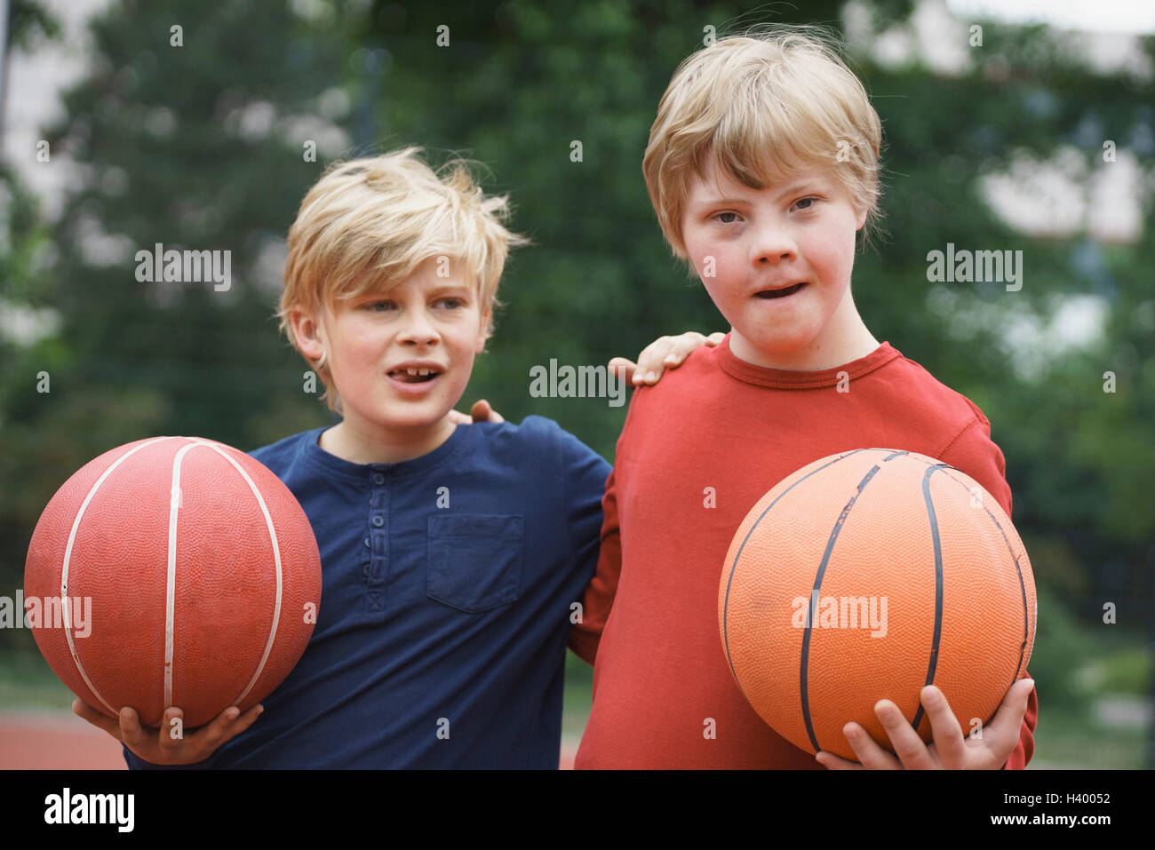 Brüder stehend Arme um gedrückter Basketbälle im park Stockfoto